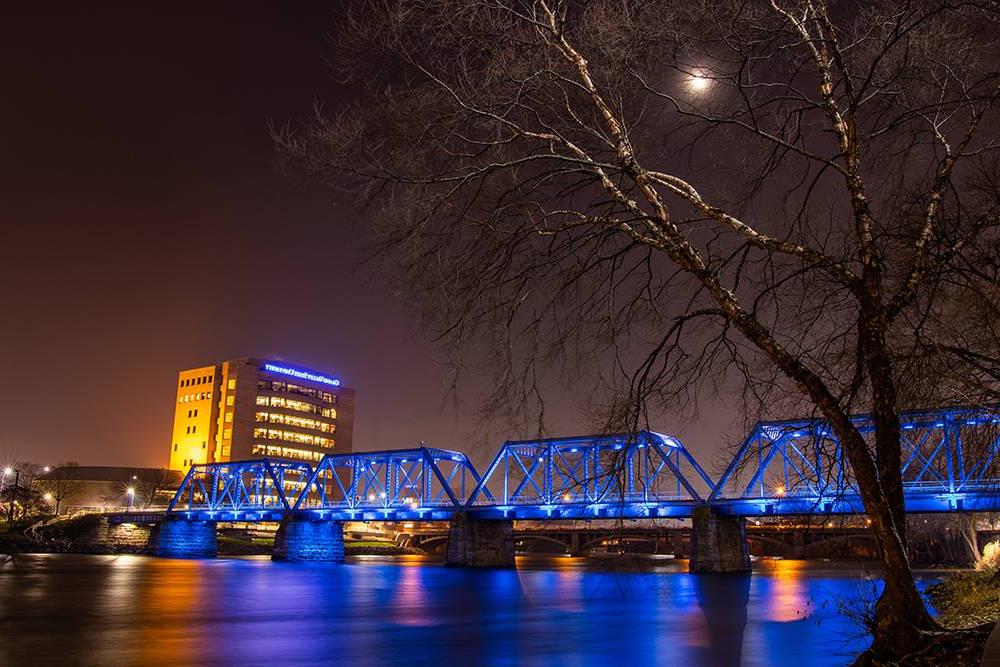 GVSU Building lit up during the night over looking Blue Bridge